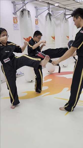 Picture of 2 kids kickboxing on a kick pad